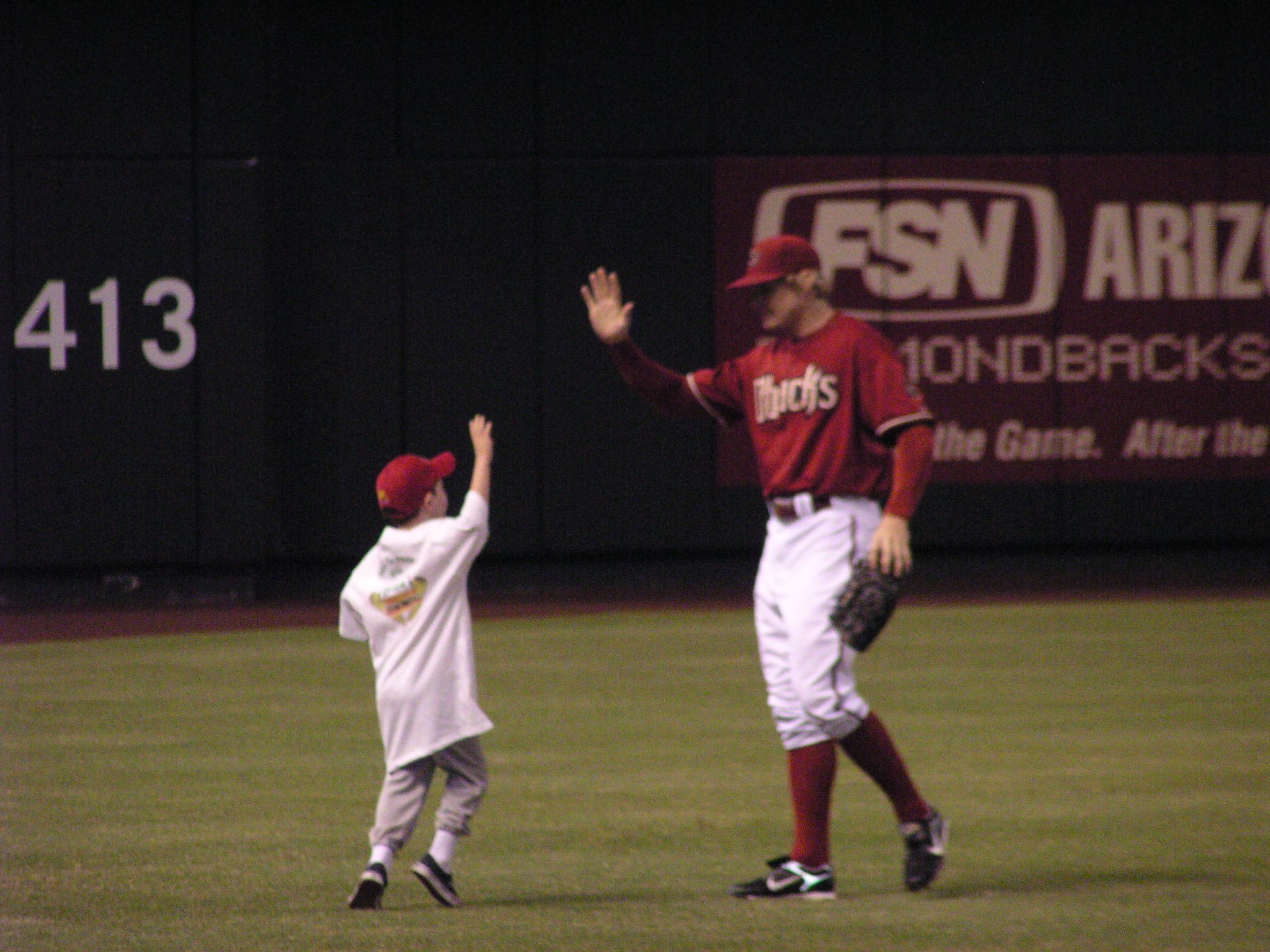 a small child (me) high fives Arizona Diamondbacks left-fielder Eric Byrnes